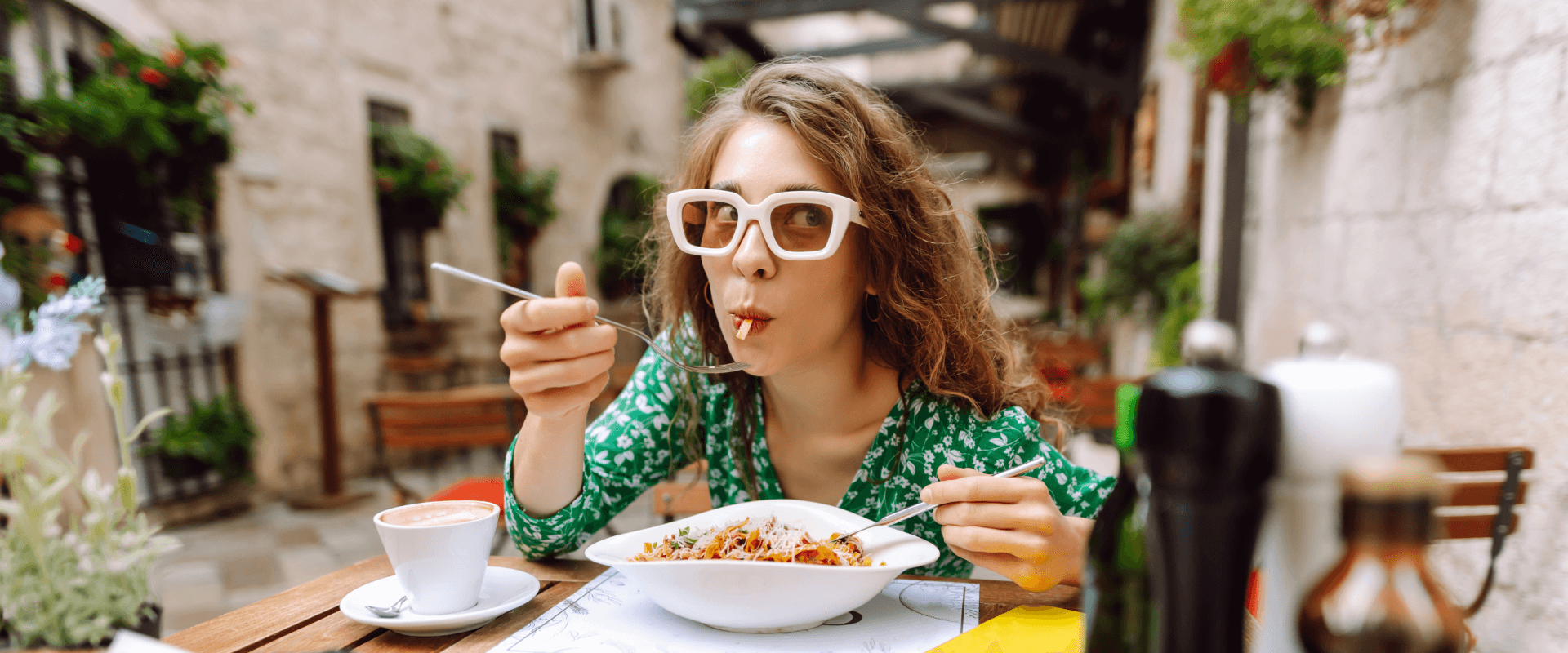 Vrouw geniet van een verse pastaschotel op terras - Header