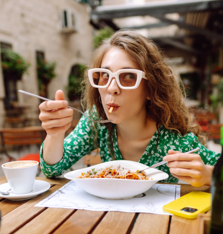 Vrouw geniet van een verse pastaschotel op terras - Thumbnail