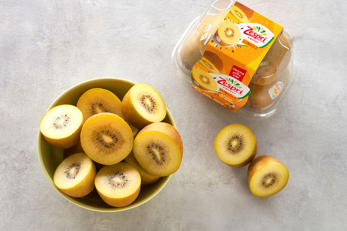 Pack of Zespri SunGold Kiwifruit along with bowl of golden kiwi fruit halves