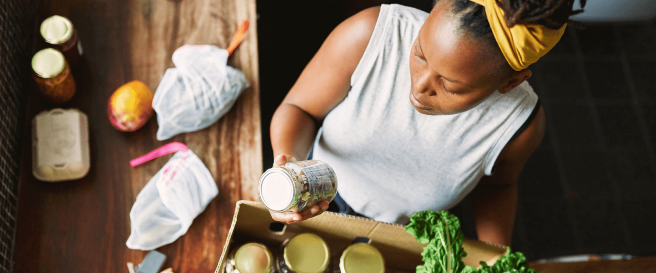 Femme lisant l’étiquette d’un bocal en verre et choisissant une alimentation consciente avec des produits frais
